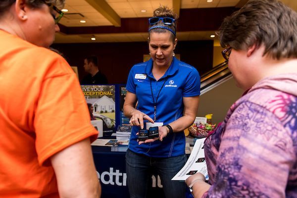 A woman in a blue shirt is talking to a group of people