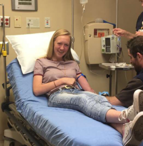 A woman is laying in a hospital bed with her legs crossed