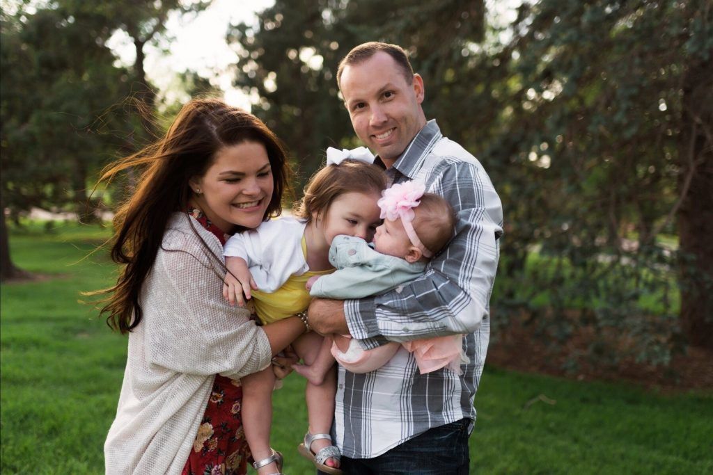 A family is posing for a picture in a park.