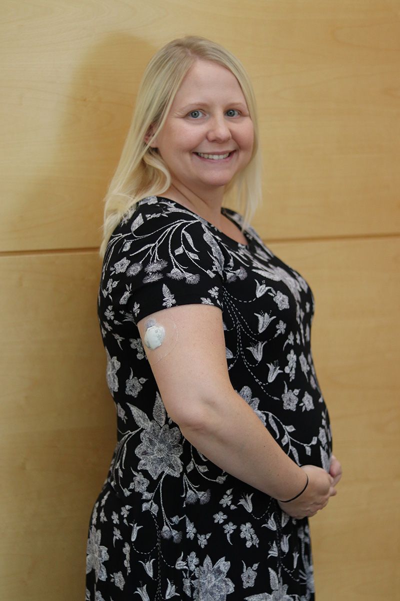 A woman in a black and white dress has a patch on her arm