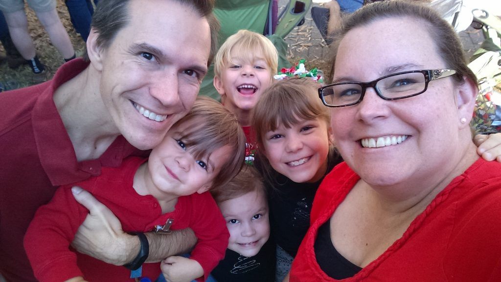 A man and a woman are posing for a picture with their children.