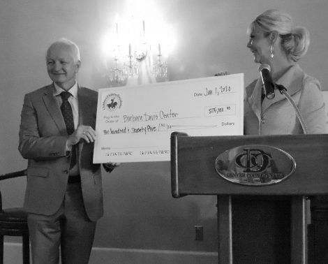 Guild member Lisa Corley presenting BDC Executive Director Dr. Rewers with large donation check.