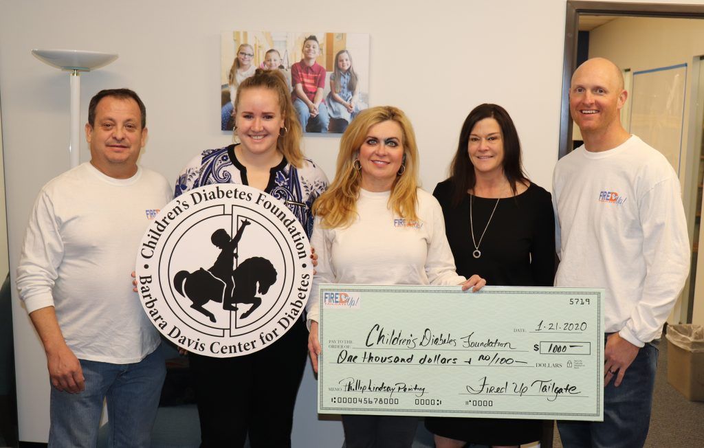 A group of people standing next to each other holding a large check.
