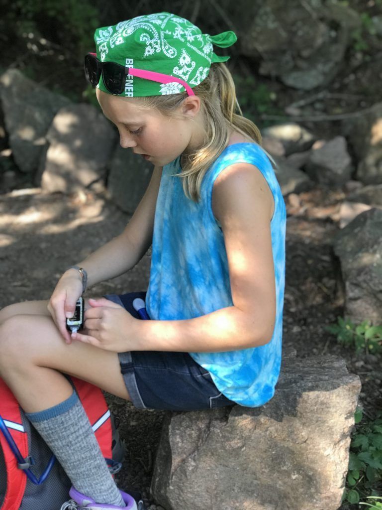 Girl with blonde hair testing her blood on her fingertip