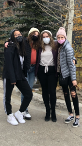 A group of young women wearing face masks are posing for a picture.
