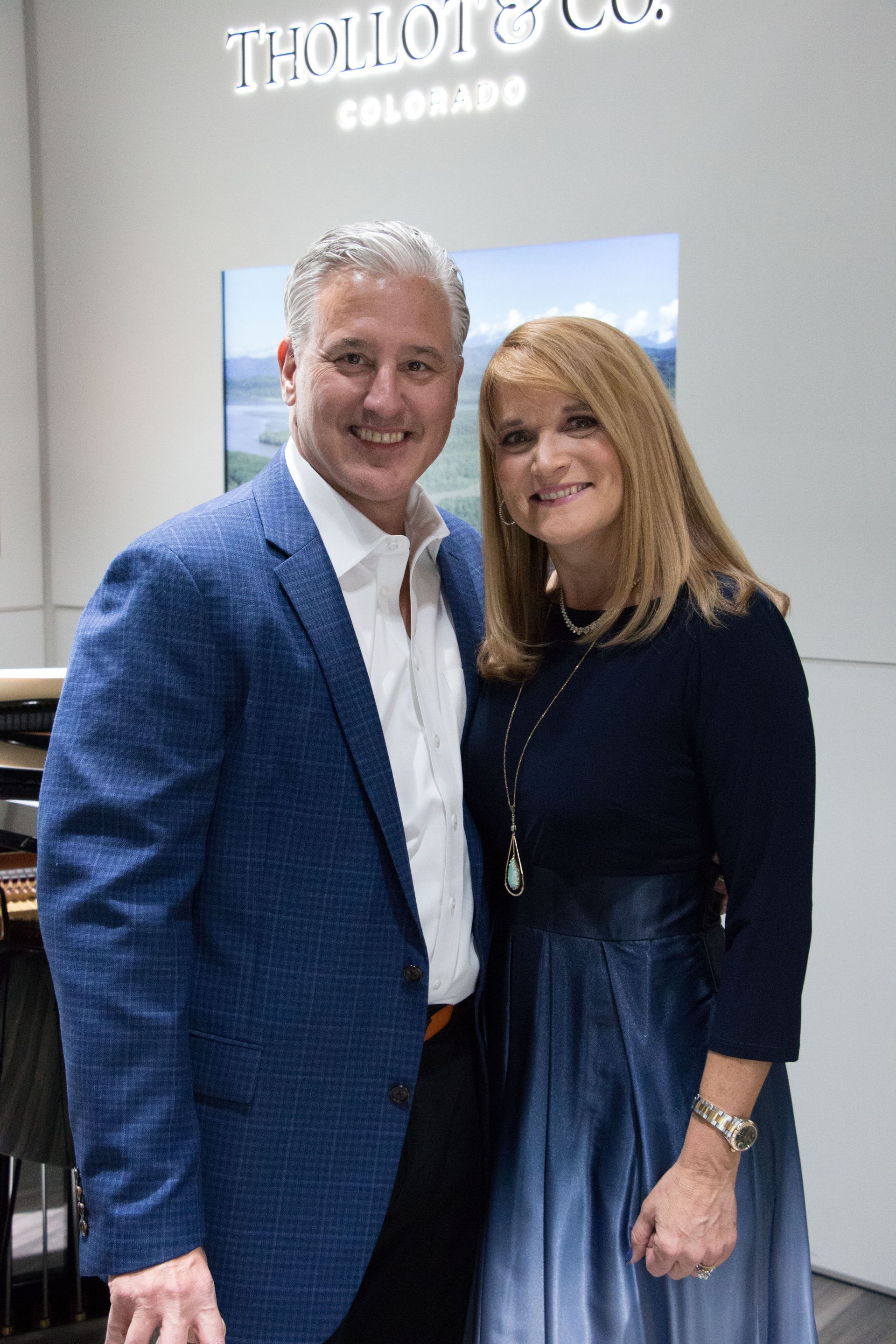 A man and a woman smiling and posing together indoors.
