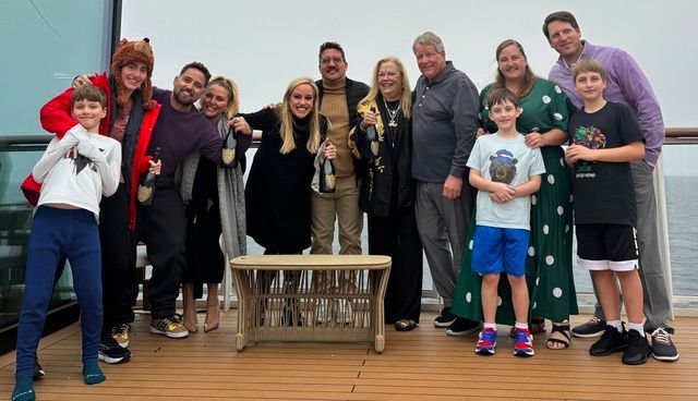 12 Members of the Macmillan family celebrating with champagne on a boat.