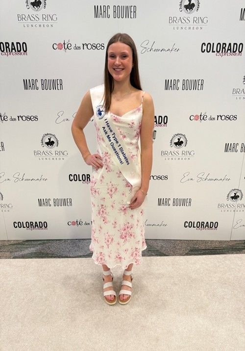 Margot at a CDF event in a dress and a CDF advocate sash asking people to ask her about T1D