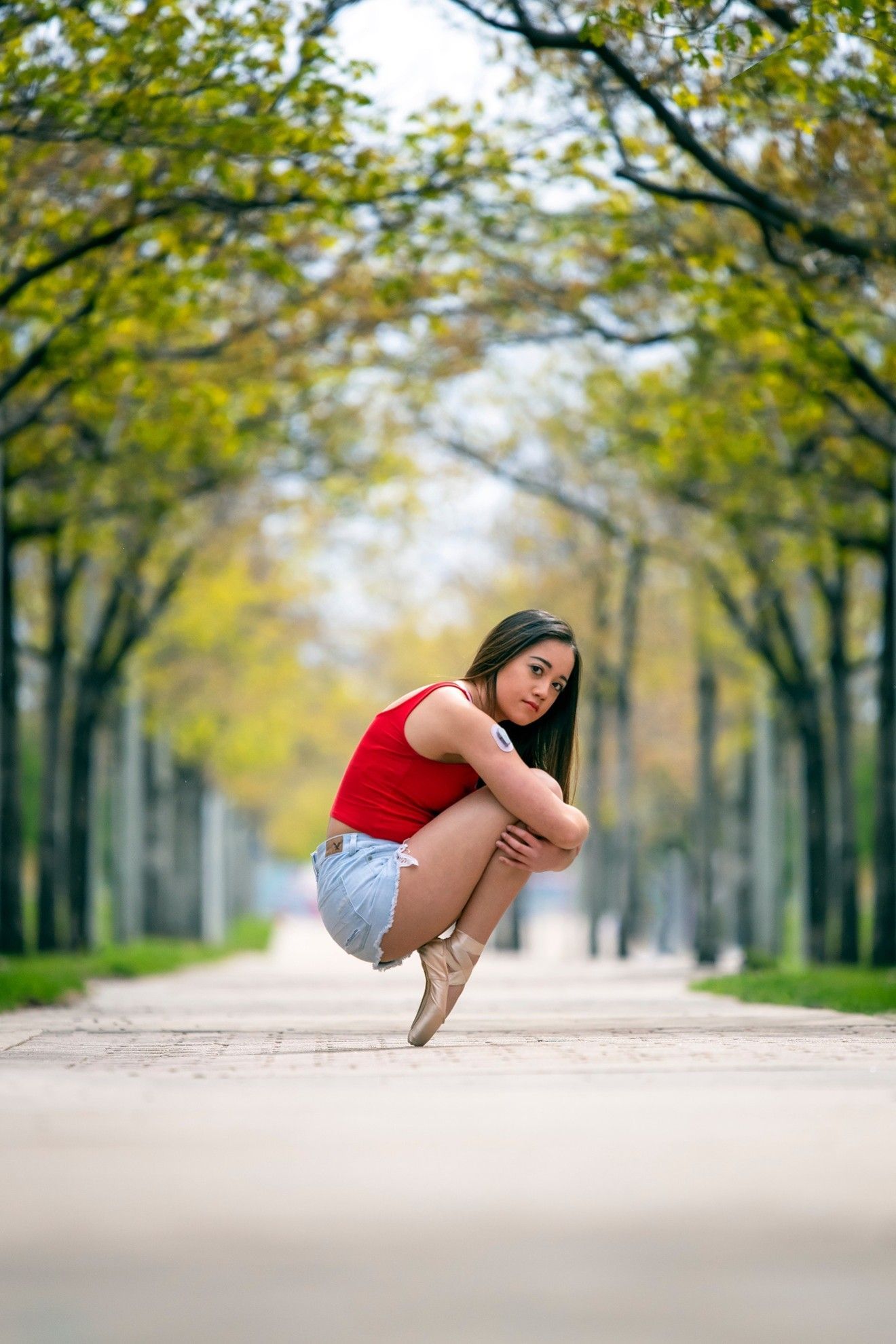 Author Sasha Amiscaray wearing her CGM and in pointe shoes