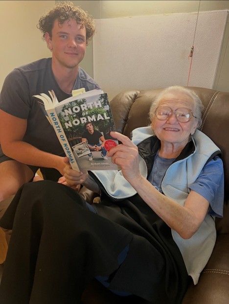 Author Wyatt Adams and his grandmother reading his book North of Normal
