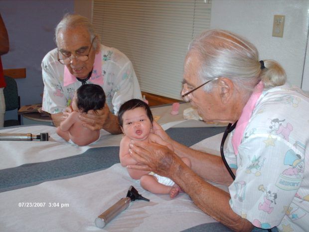 A baby is being examined by a doctor with a stethoscope