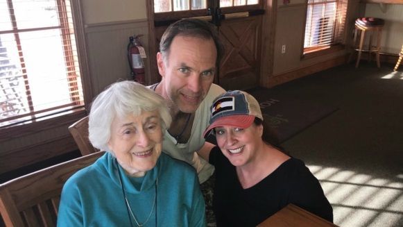 A man and two women are posing for a picture in a room.
