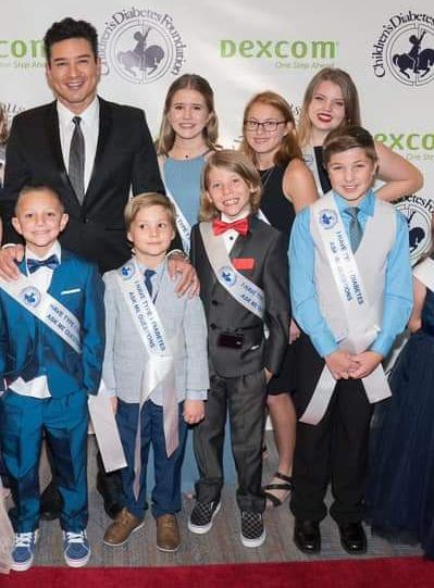 A group of children are posing for a picture in front of a sign that says dexcom