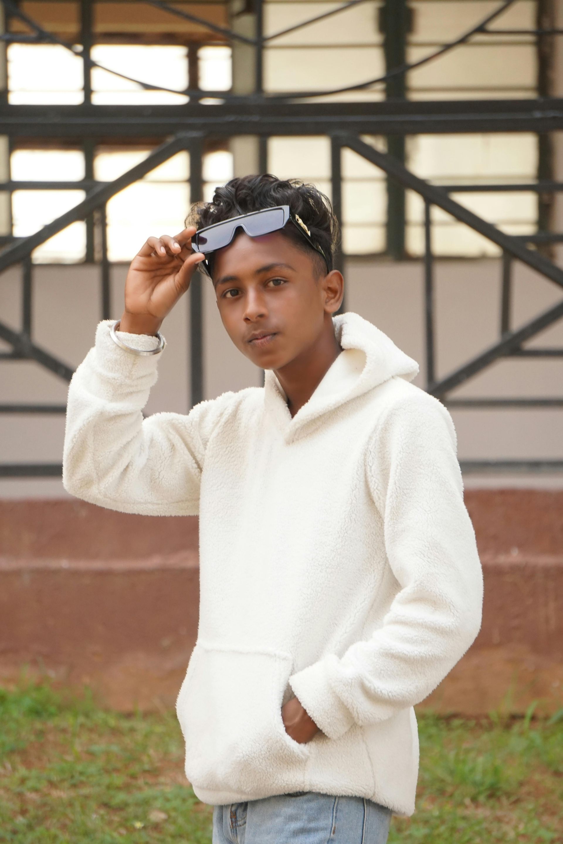 Teenage boy in sunglasses and white sweatshirt.