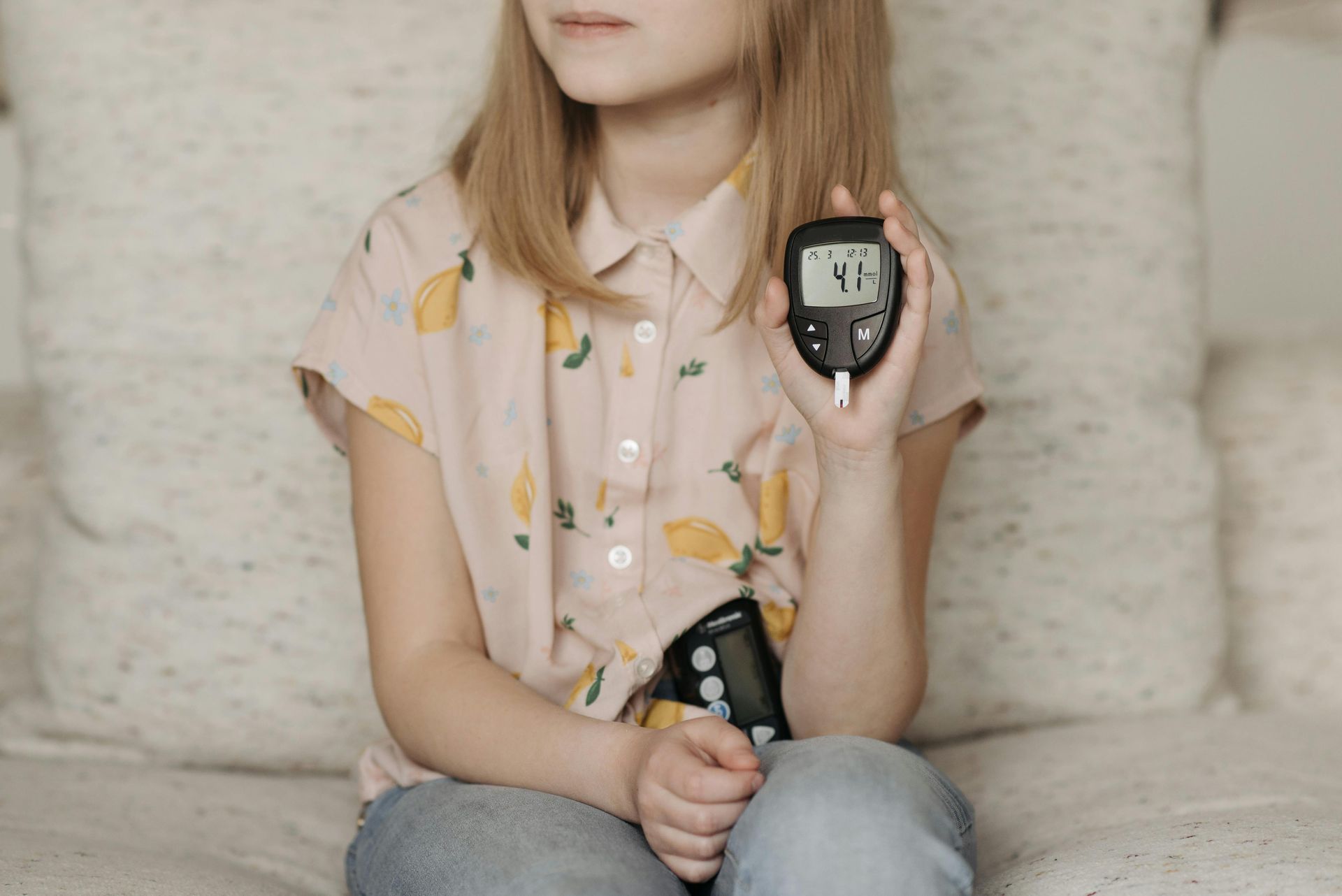 Young girl with her blood glucose monitor and insulin pump