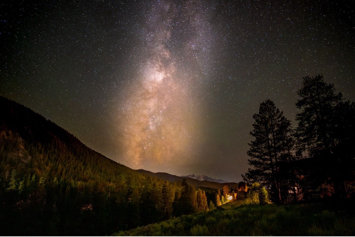 Cloudy night with moon shining through in the mountains.