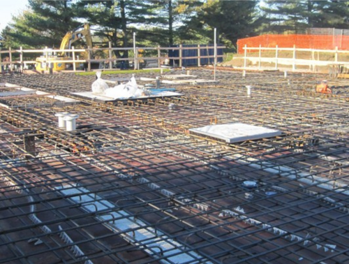 Chantier avec armature métallique préparée pour le coulage du béton.