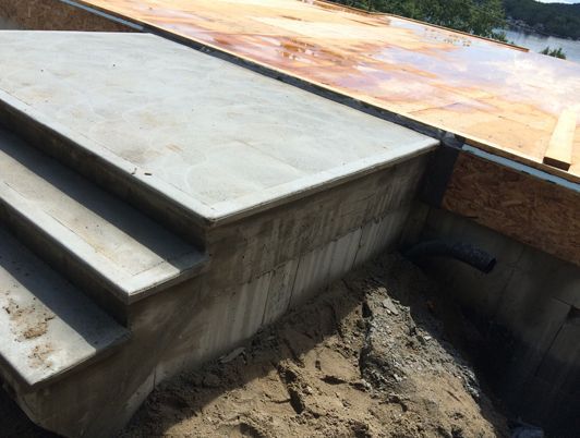 Escaliers en béton menant à une structure de terrasse en bois. Milieu de chantier.