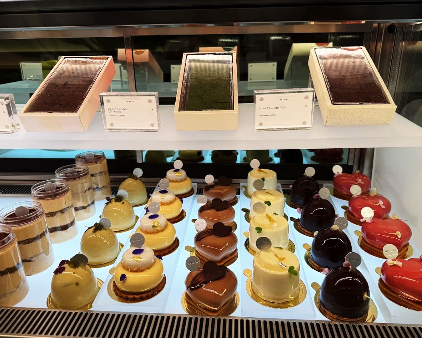 Elegant pastries combining Japanese precision and French techniques, arranged neatly in a modern dessert display.