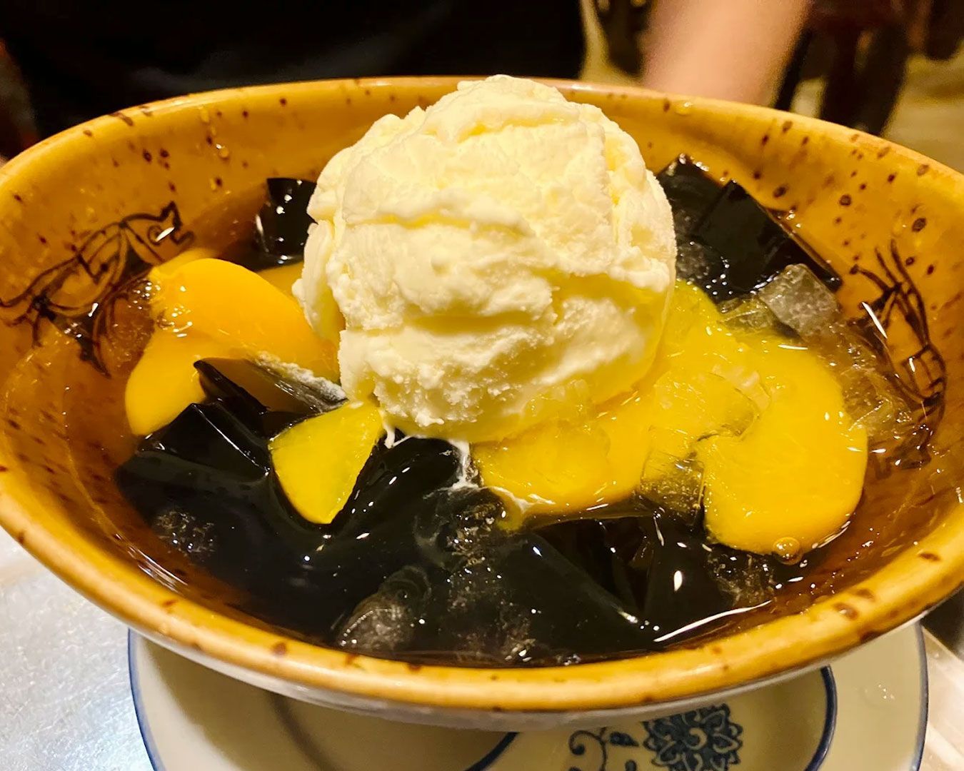 A light and colourful bowl of traditional Chinese dessert with shaved ice, fresh fruits, and sweet herbal syrup for a cooling finish.