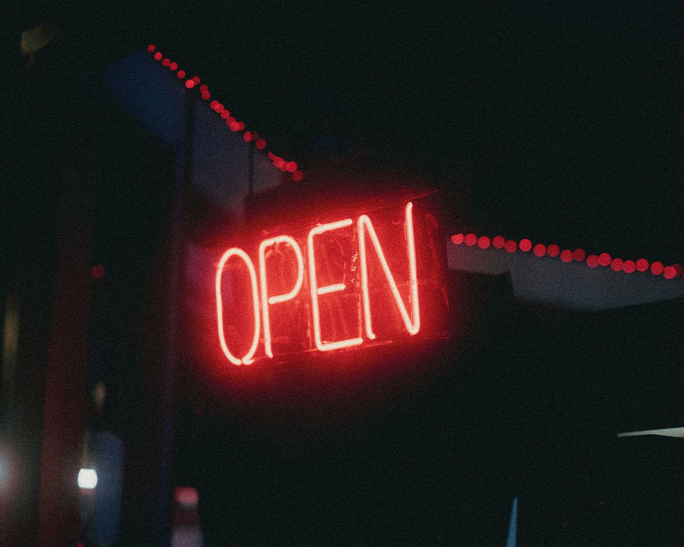 An illuminated “Open” sign hanging at the shop entrance, signalling that the dessert store is welcoming customers inside.