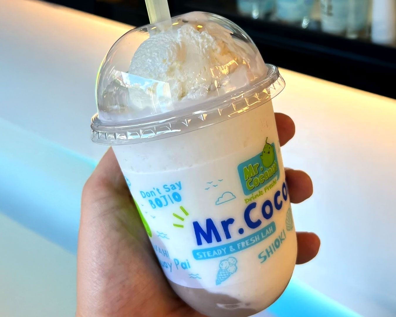 Chilled coconut beverages blended with milk and fruit, served in clear cups that highlight their creamy layers.