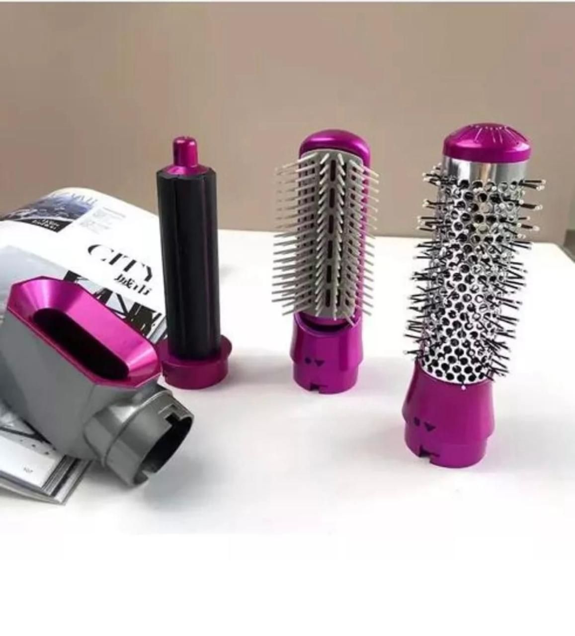 Plancha de pelo multifunción de color rosa y plata con accesorios para distintos estilos sobre fondo blanco.