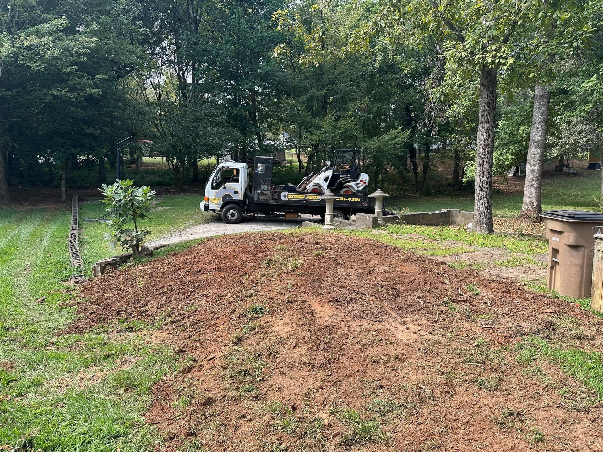 A tow truck is parked in the middle of a grassy field.