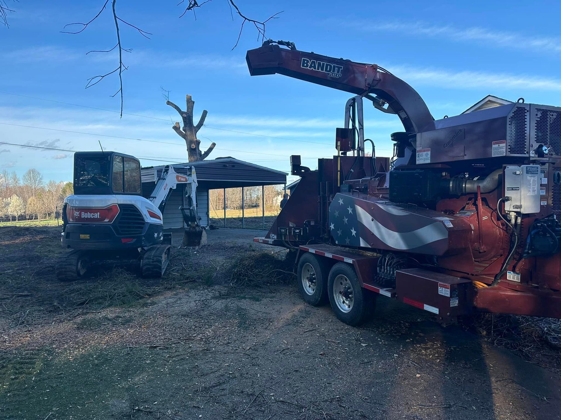 A tree chipper is sitting on top of a trailer in a yard.