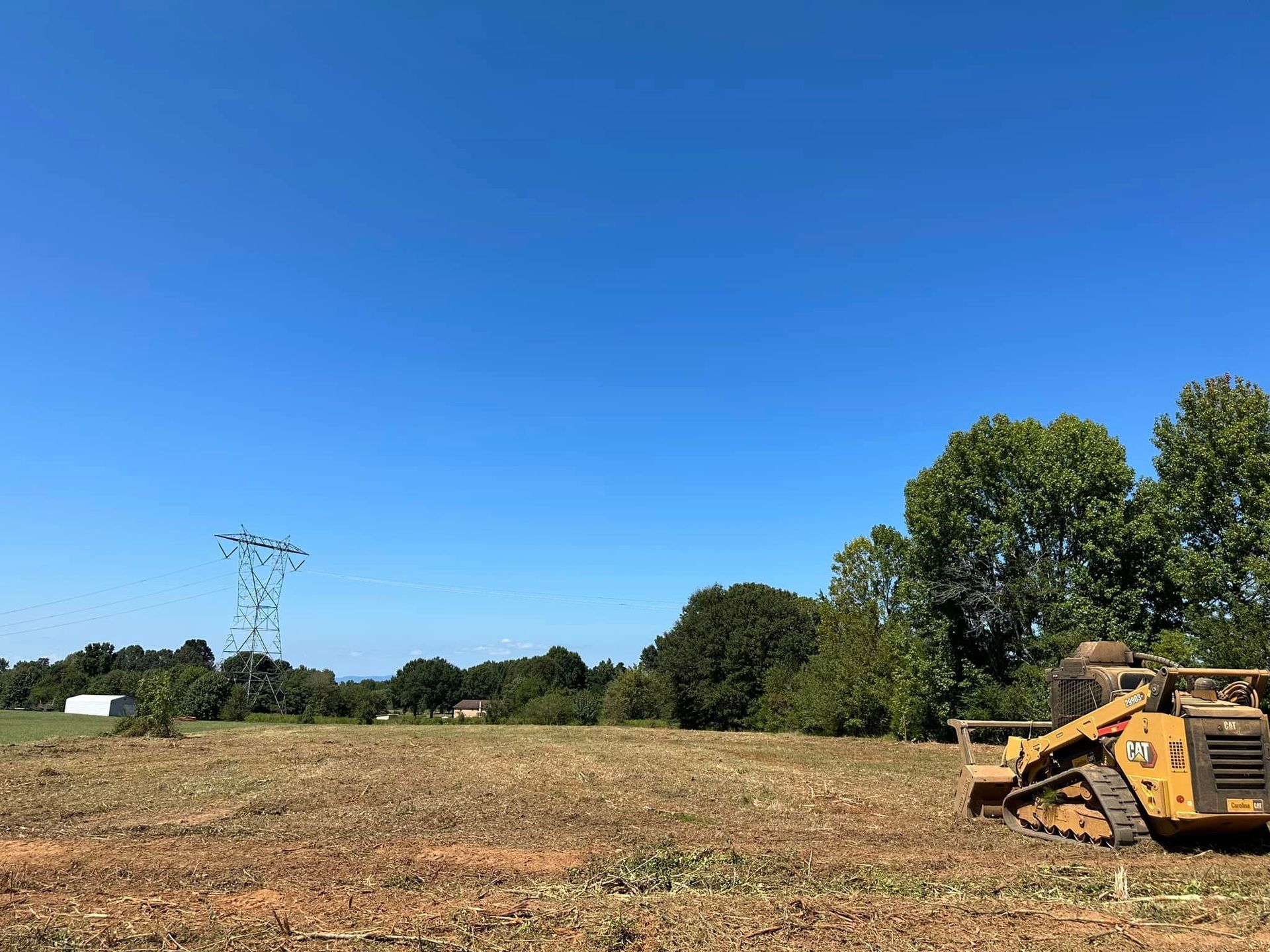 A bulldozer is sitting in the middle of a field.