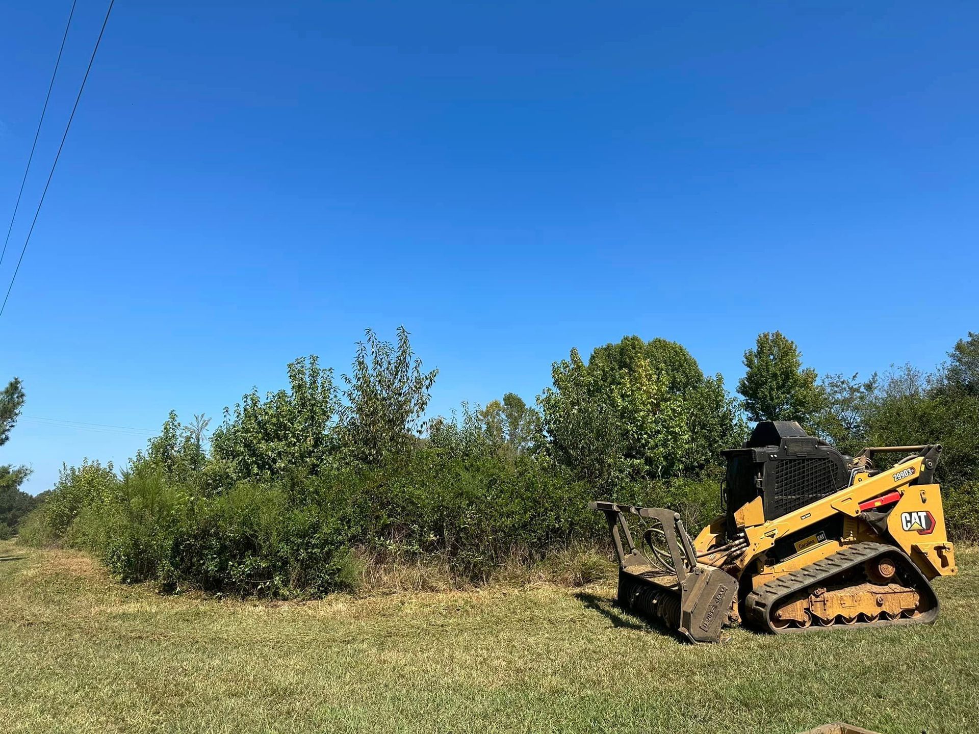 A bulldozer is sitting in the middle of a grassy field.