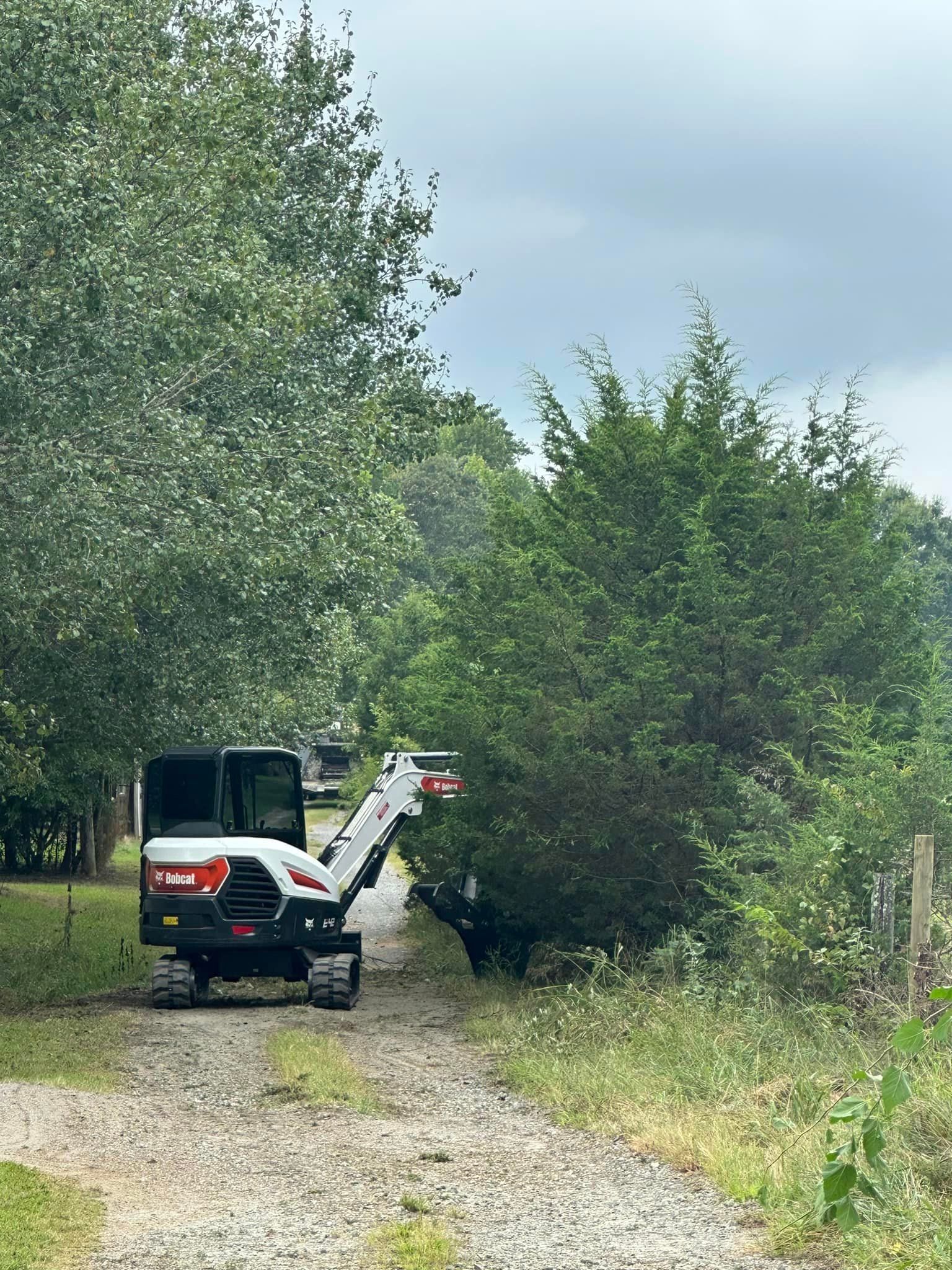A small excavator is parked on the side of a gravel road.