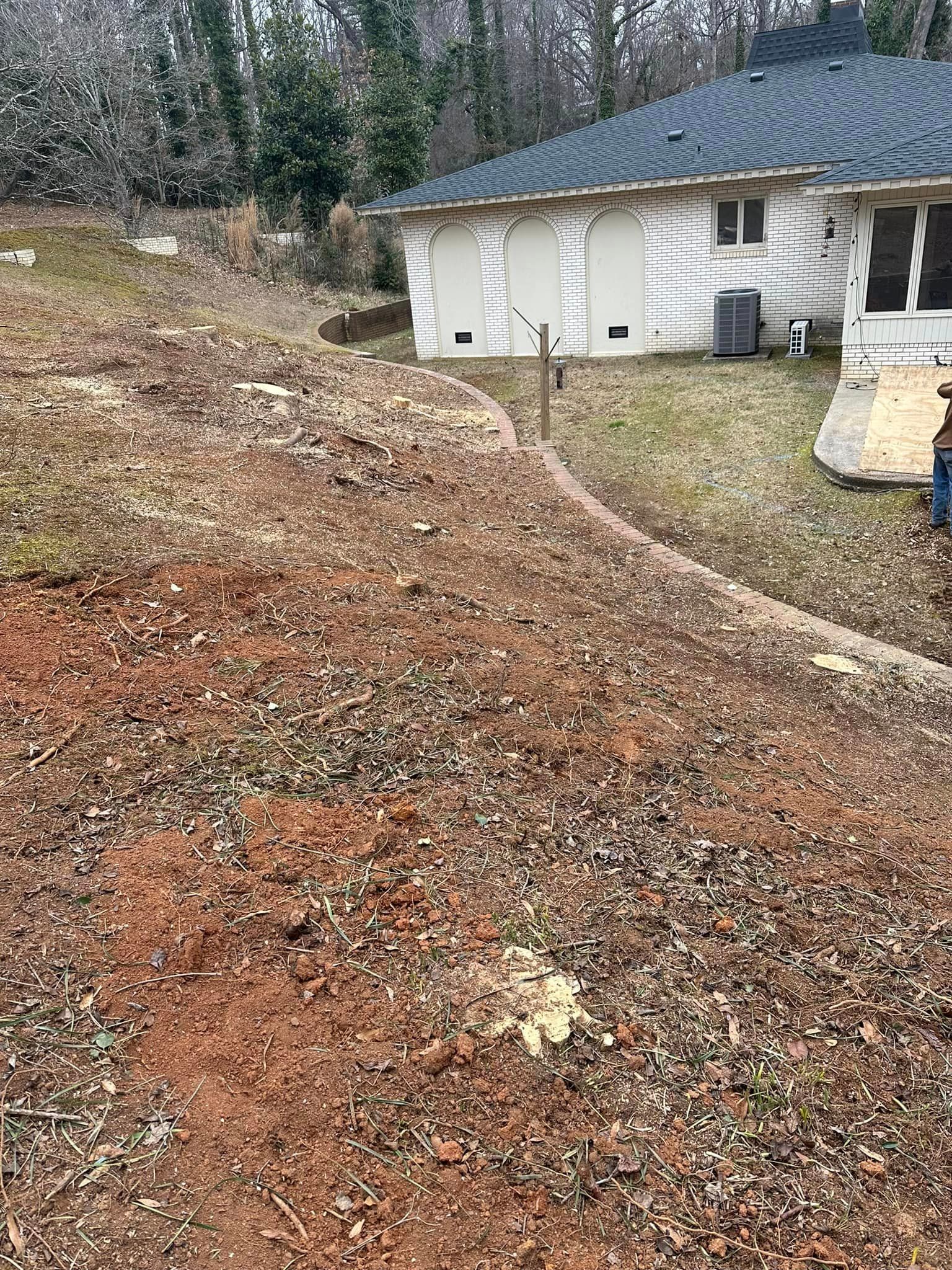 A house is sitting on top of a hill next to a dirt field.