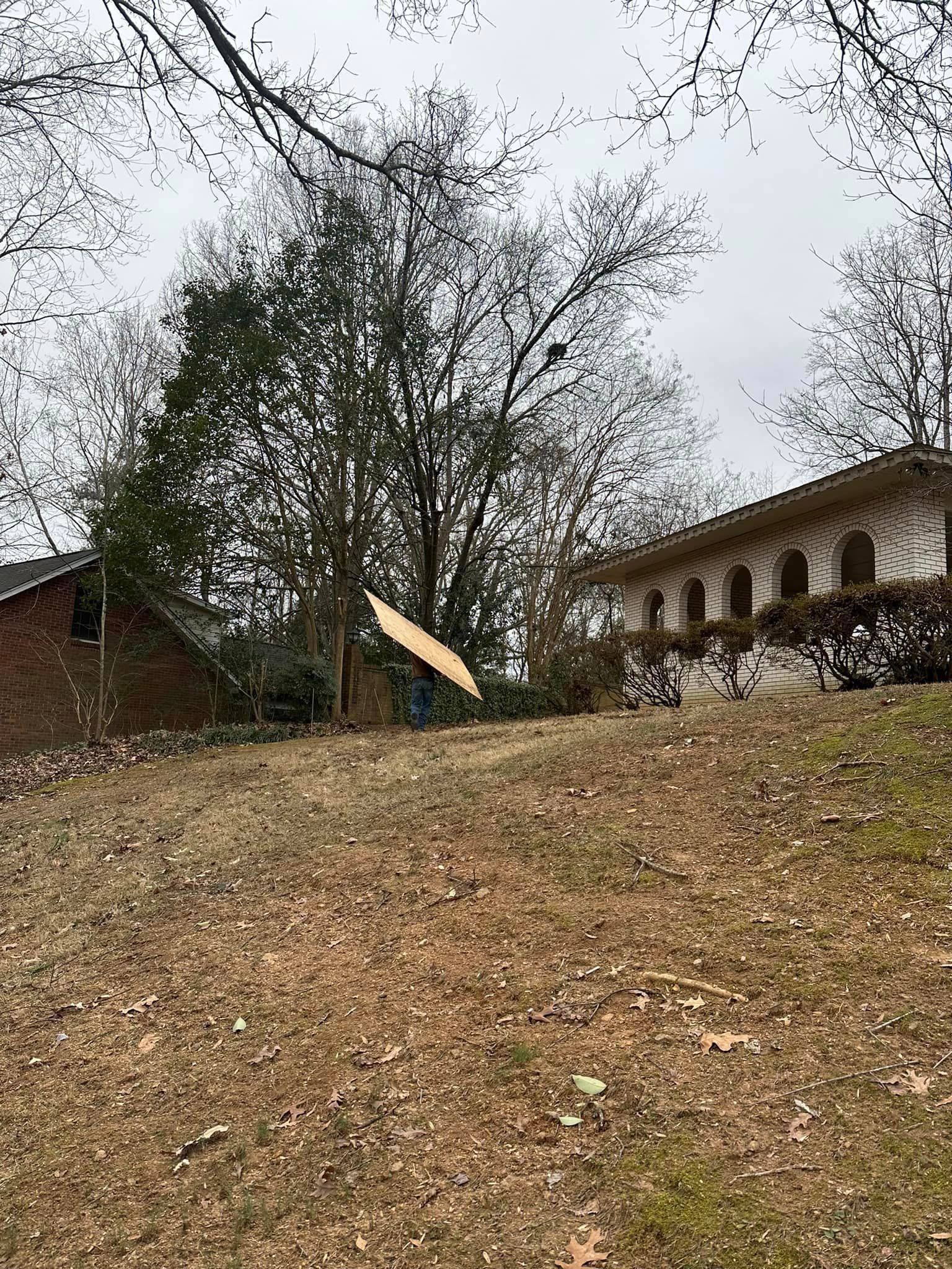 A person is throwing a frisbee in the air in front of a house.