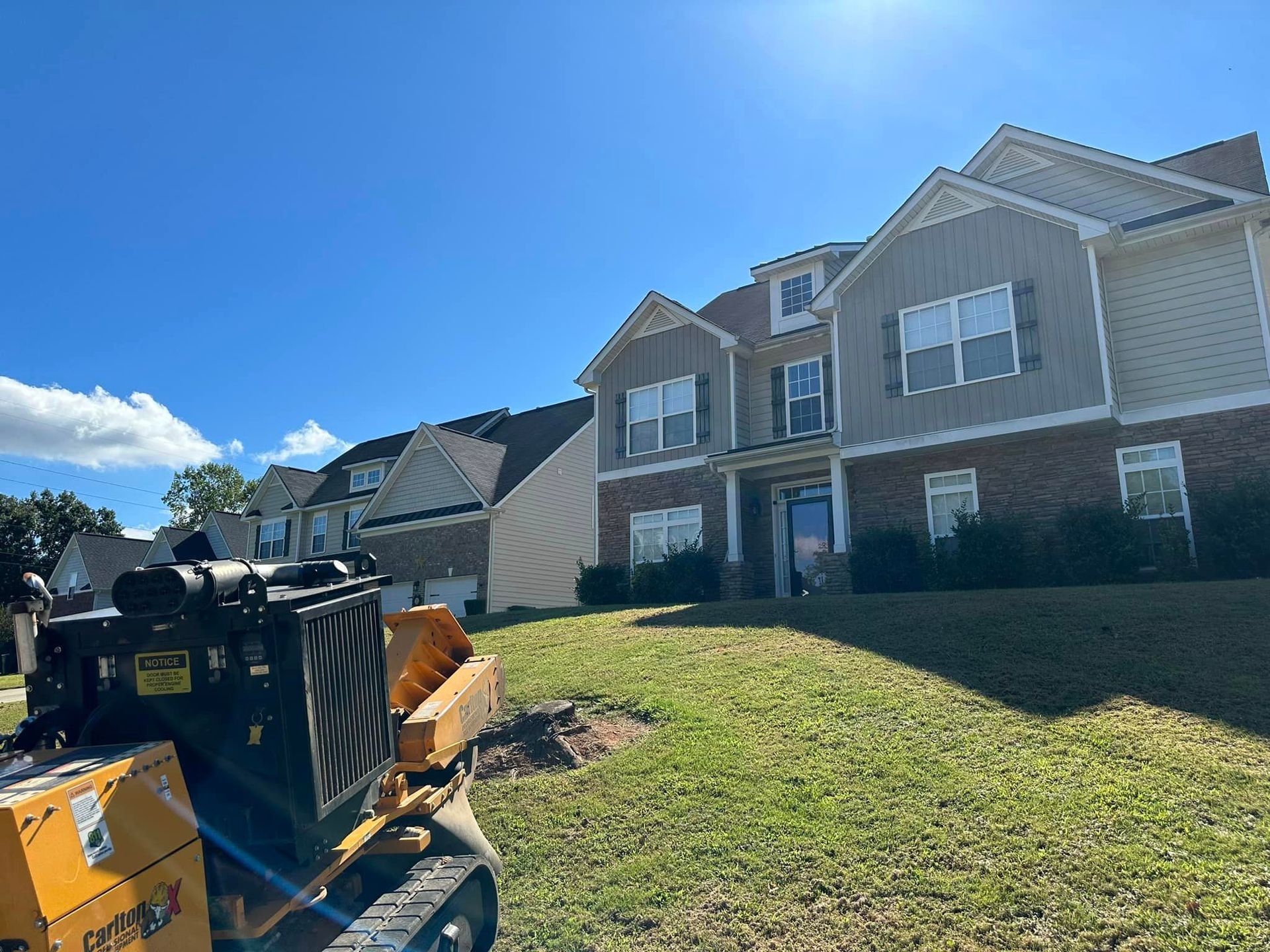 A large house with a tractor in front of it.