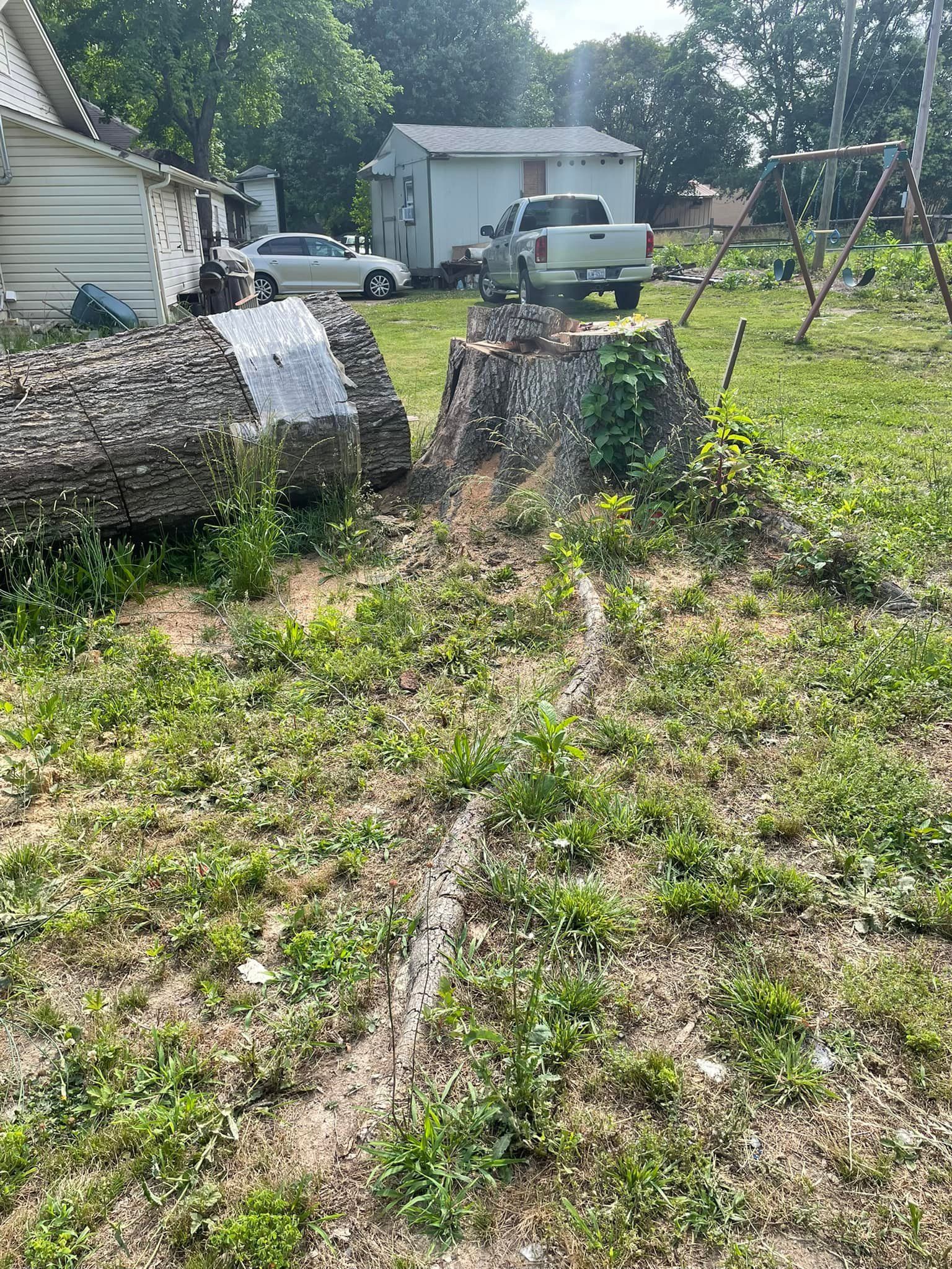 A truck is parked in the grass in front of a house.