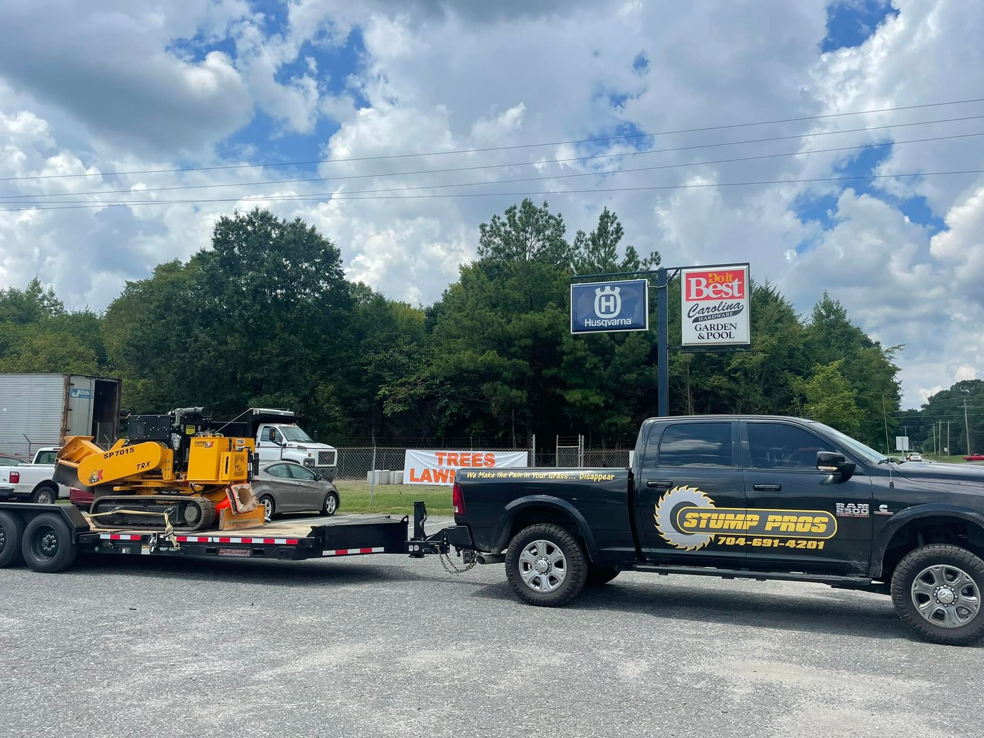 A truck is towing a trailer with a bulldozer on it.