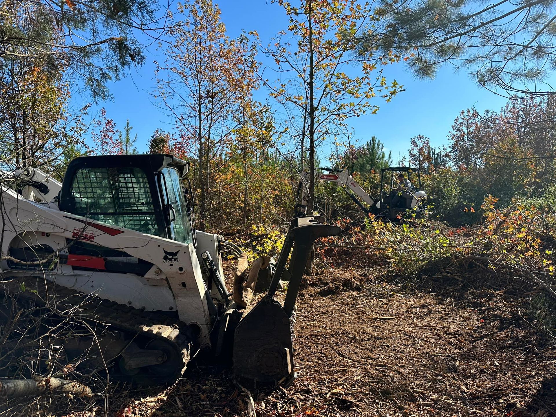 A bulldozer is parked in a field with trees in the background.