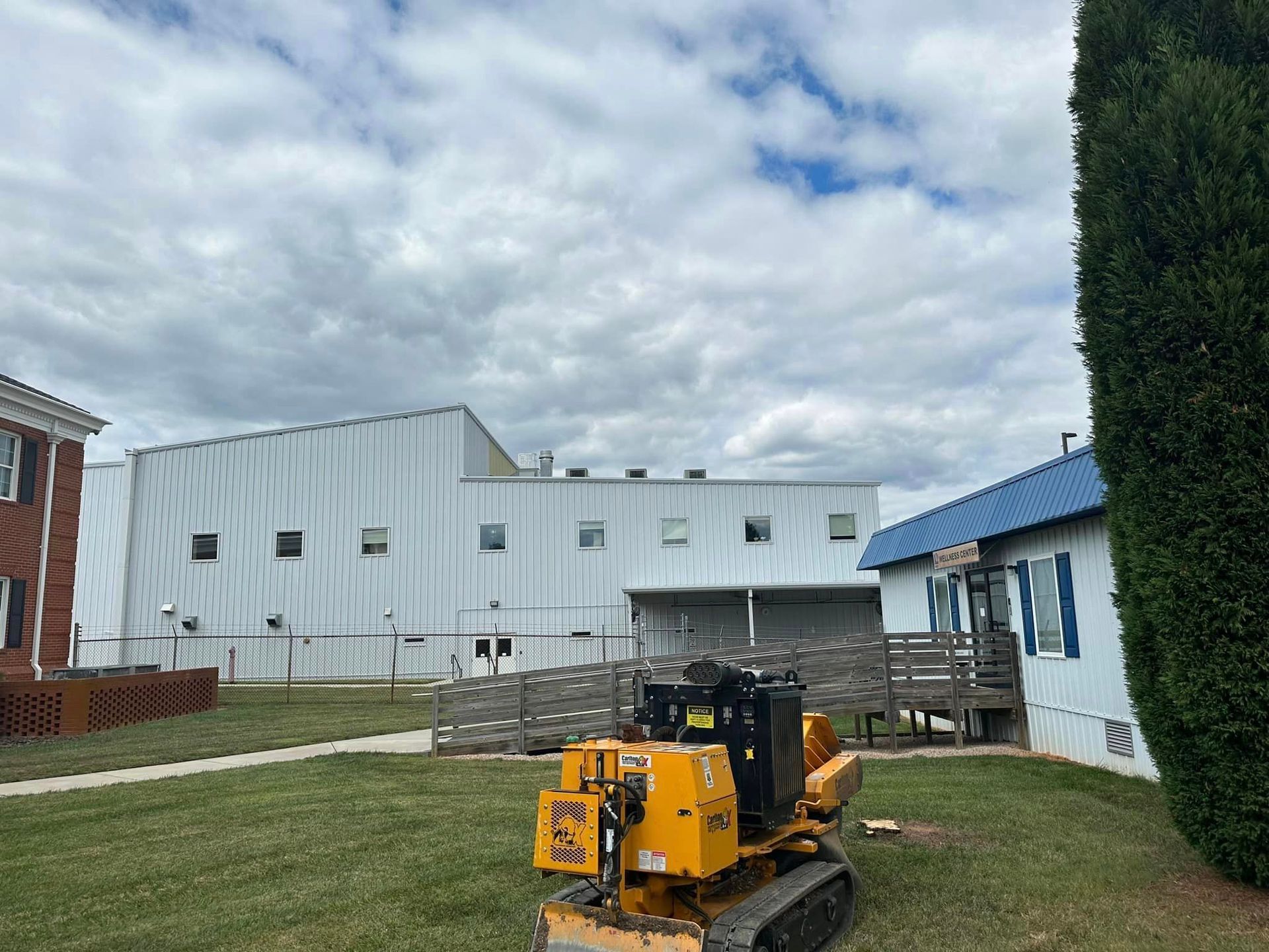 A tree stump grinder is sitting in front of a building.