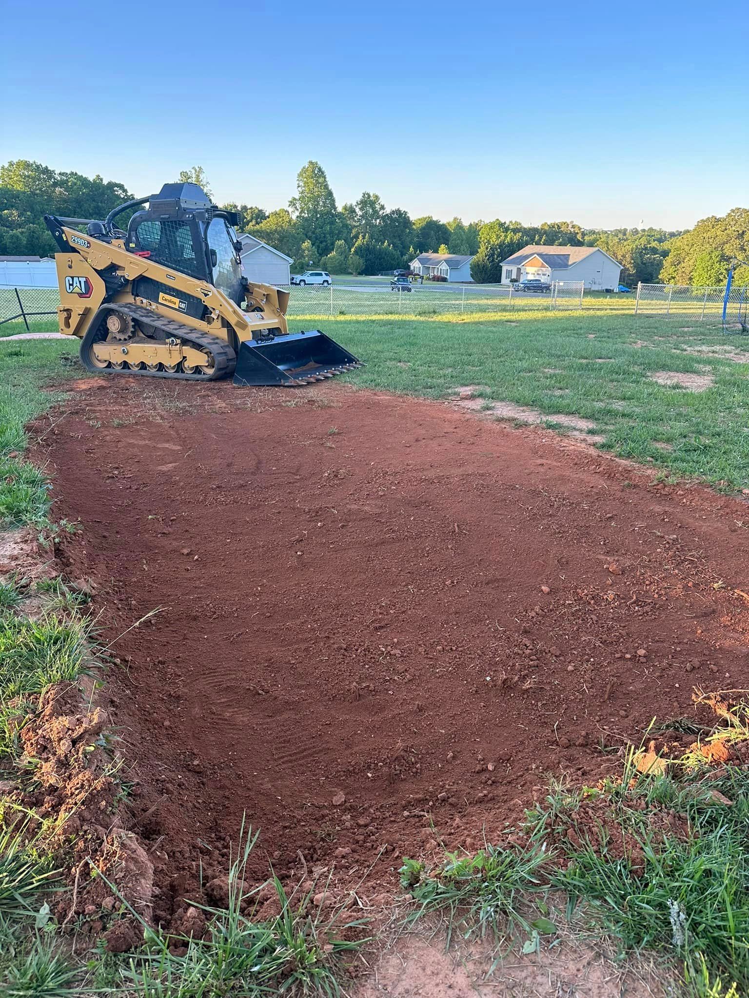 A bulldozer is digging a hole in the dirt in a field.