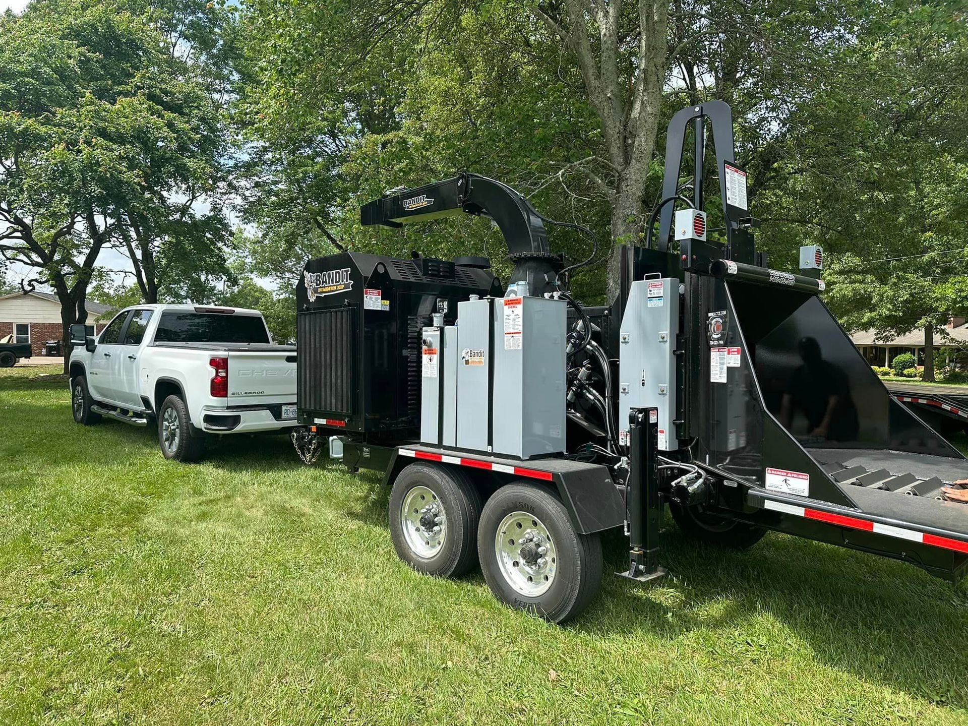 A truck is towing a tree chipper on a trailer.