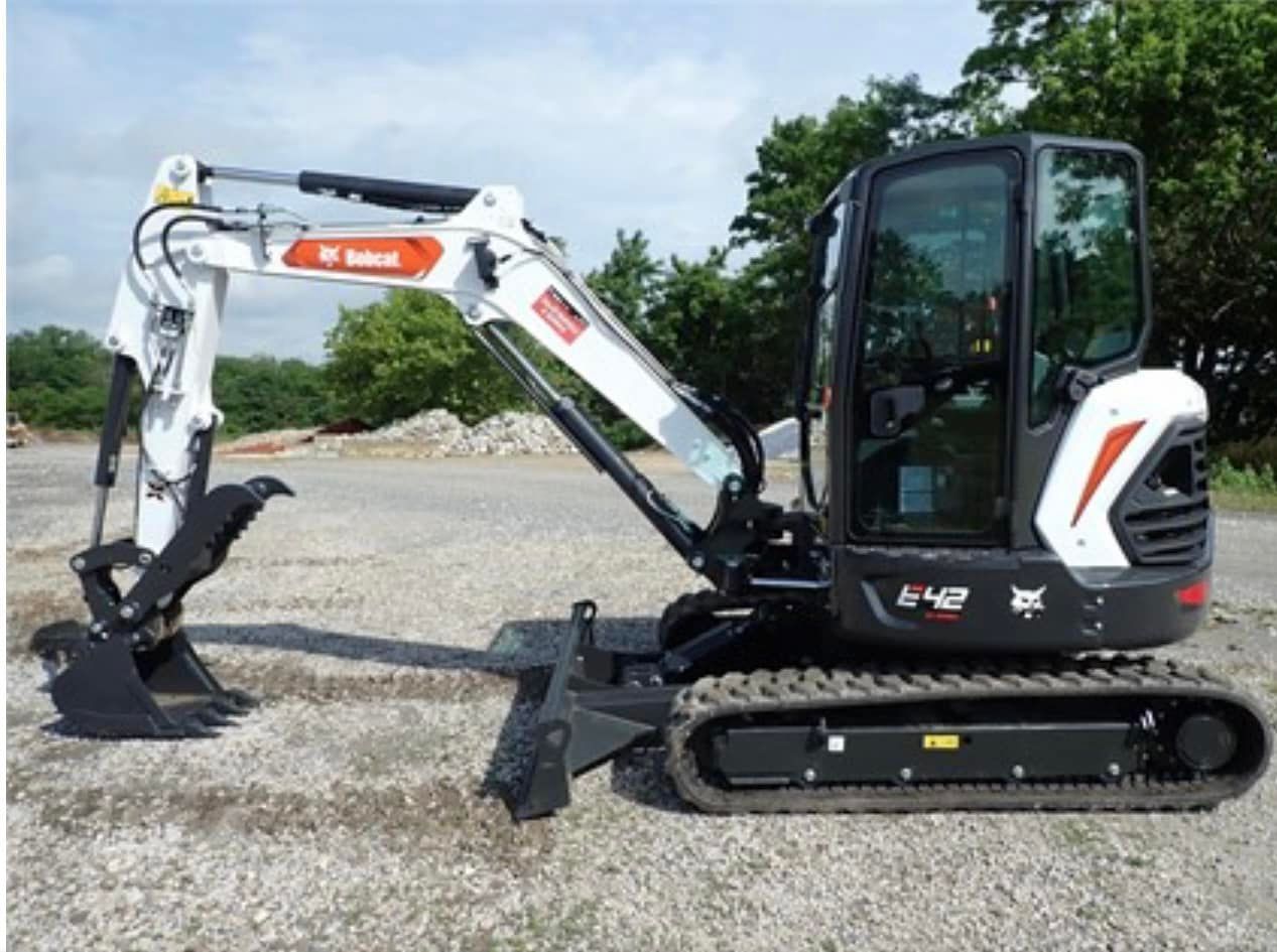 A bobcat excavator is parked in a gravel lot