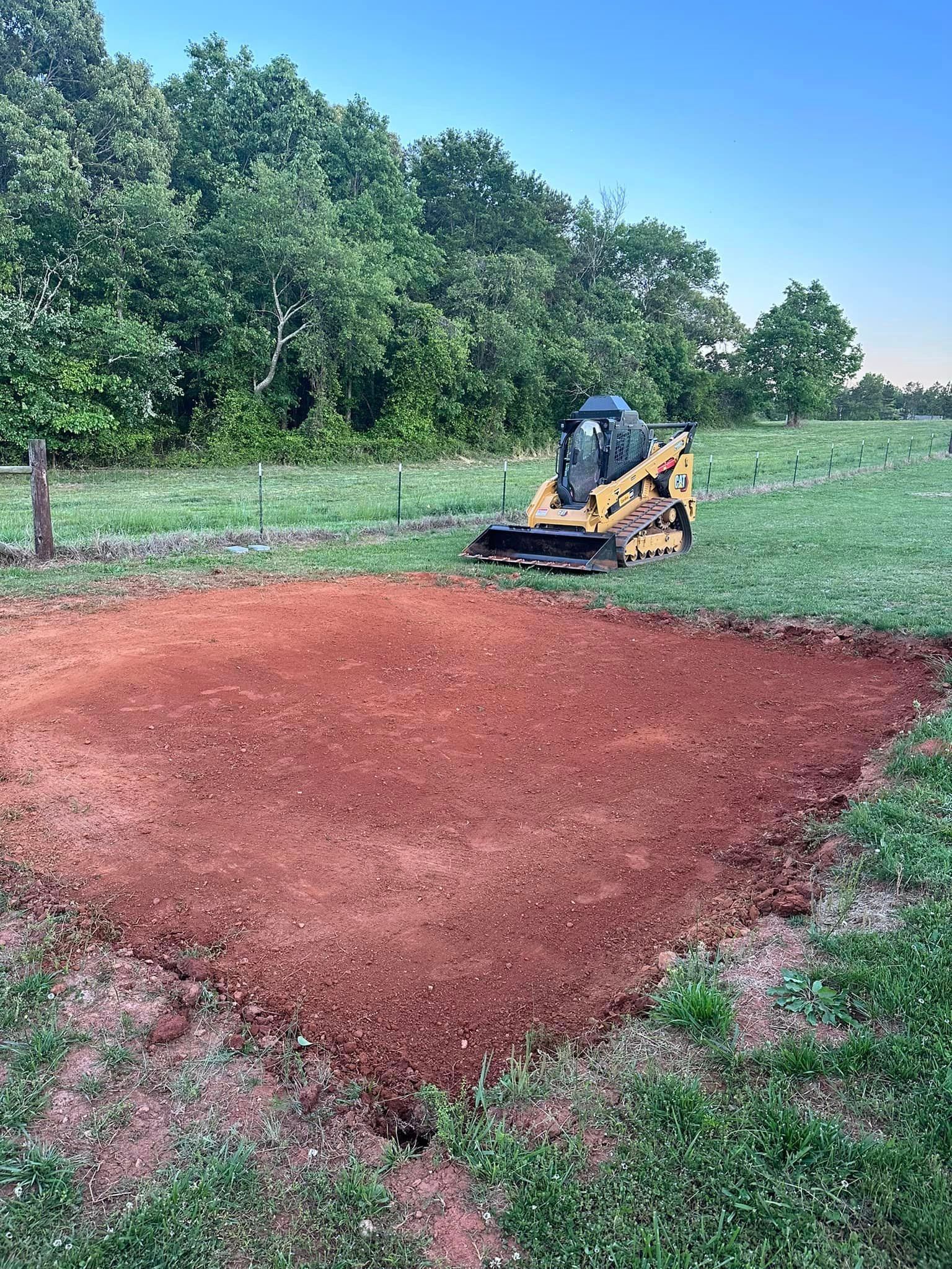 A bulldozer is moving dirt in a field.