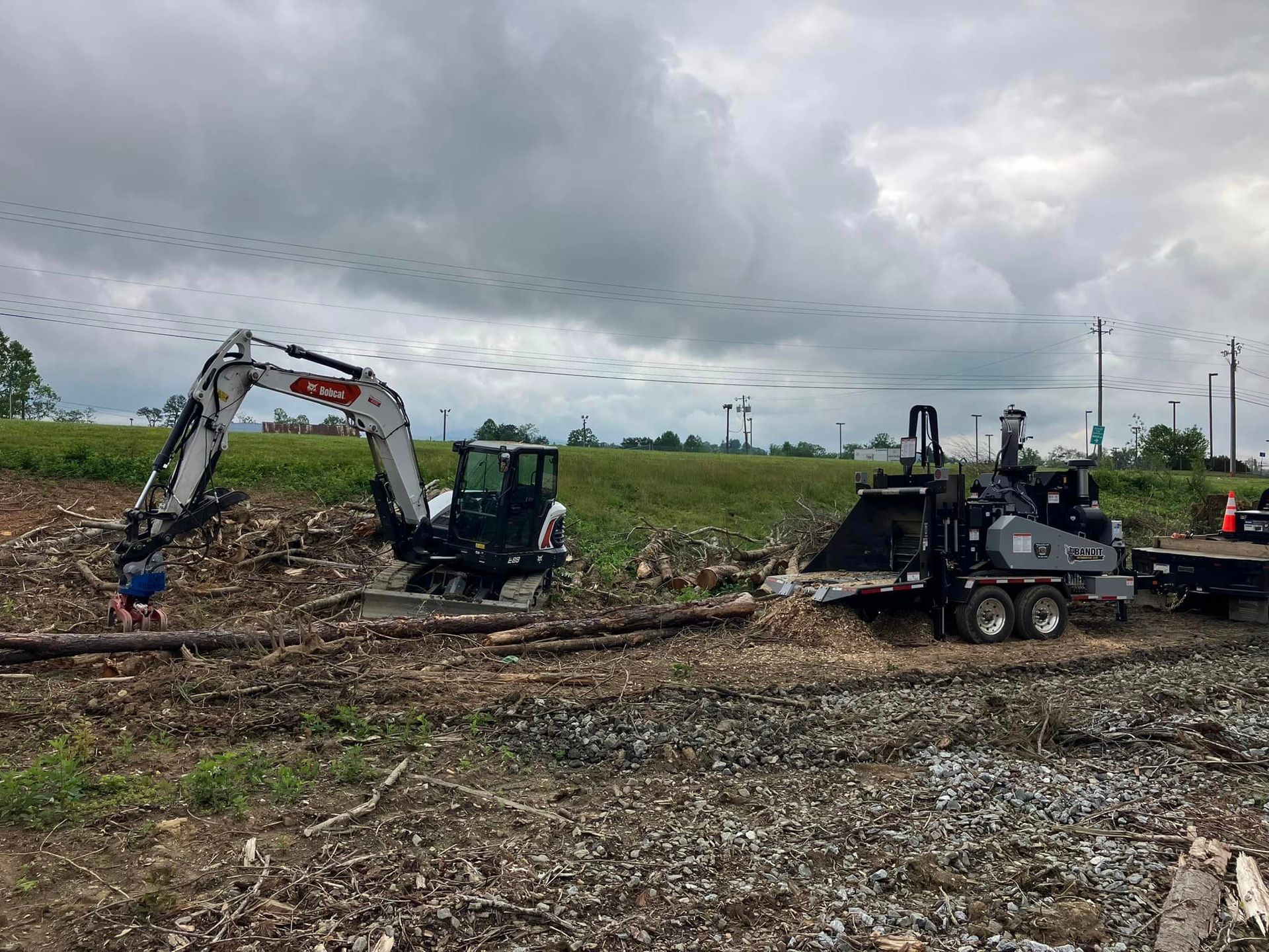 A couple of tractors are sitting on top of a trailer in a field.