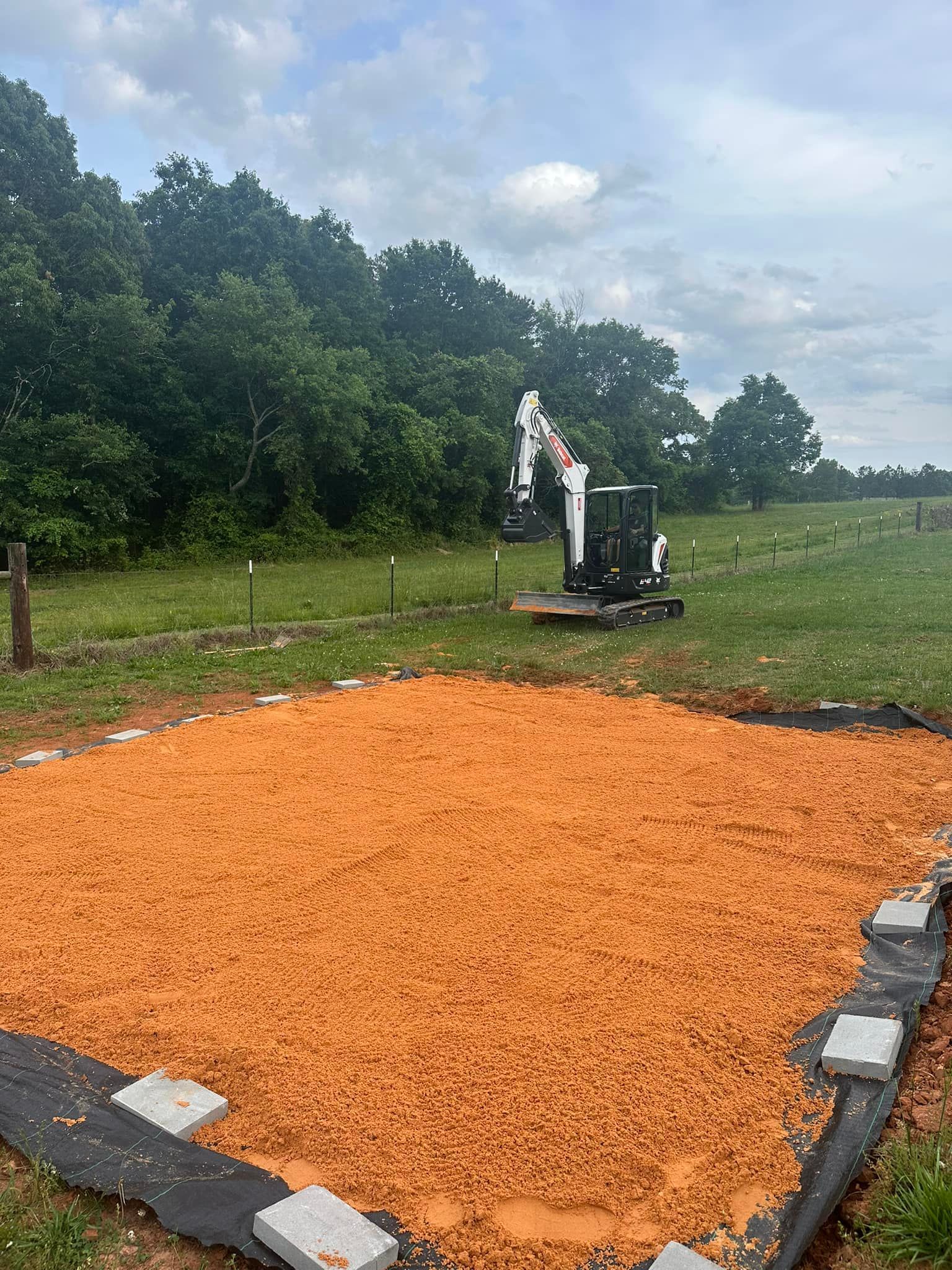 A bulldozer is sitting on top of a pile of dirt in a field.