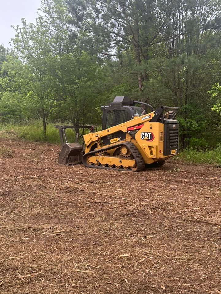 A yellow bulldozer is sitting in the middle of a dirt field.