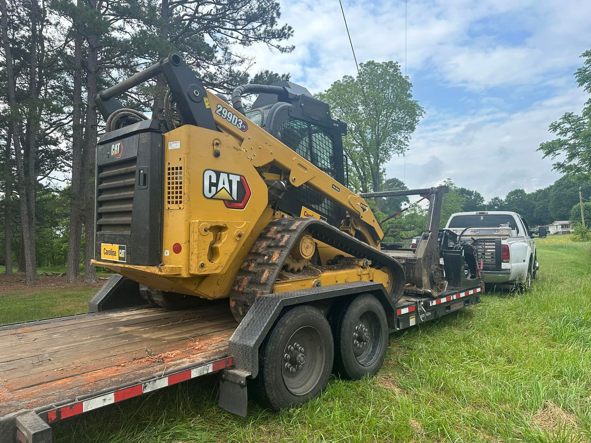 A bulldozer is being towed by a truck on a trailer.