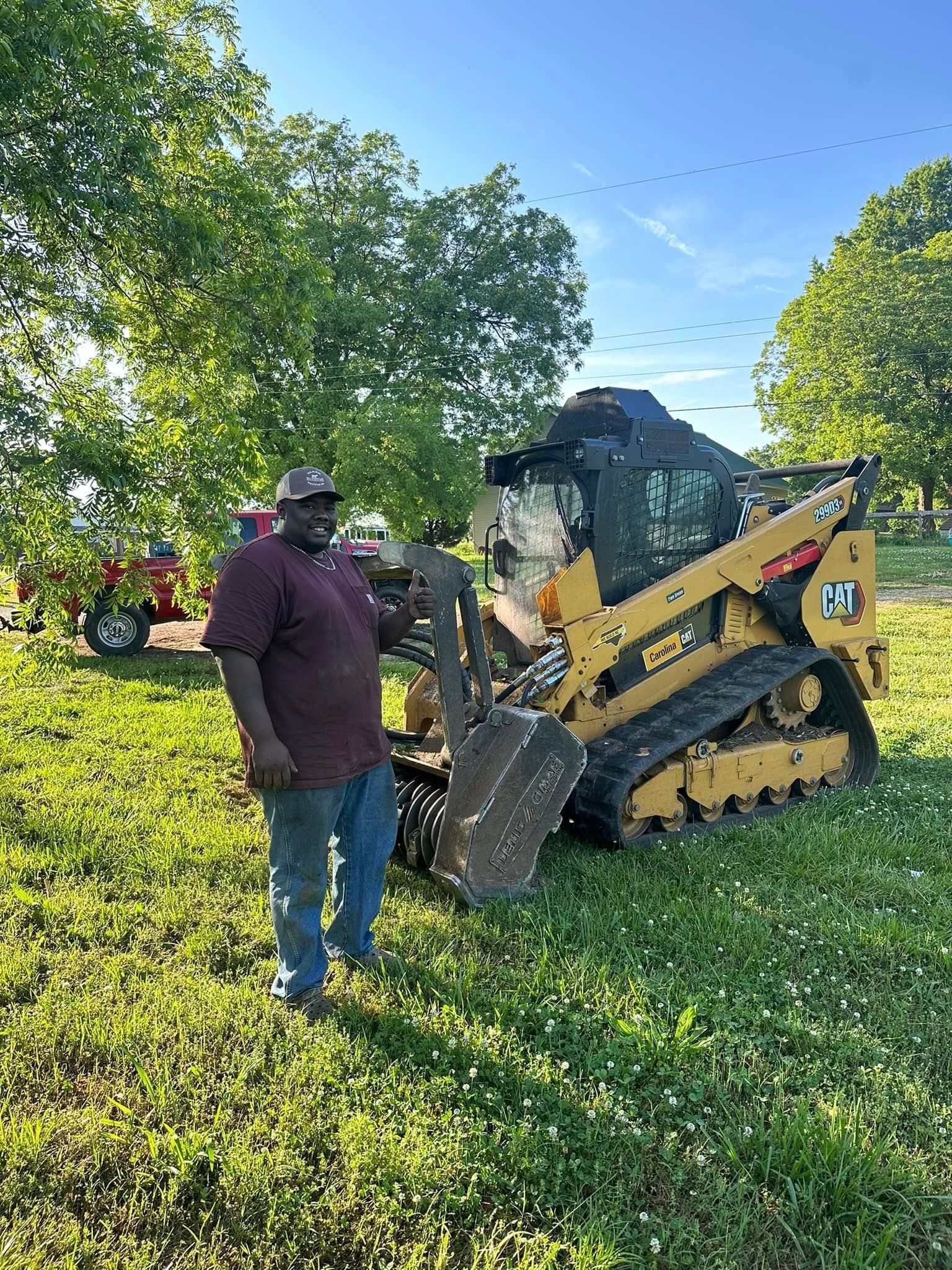A man is standing in front of a bulldozer in a field.
