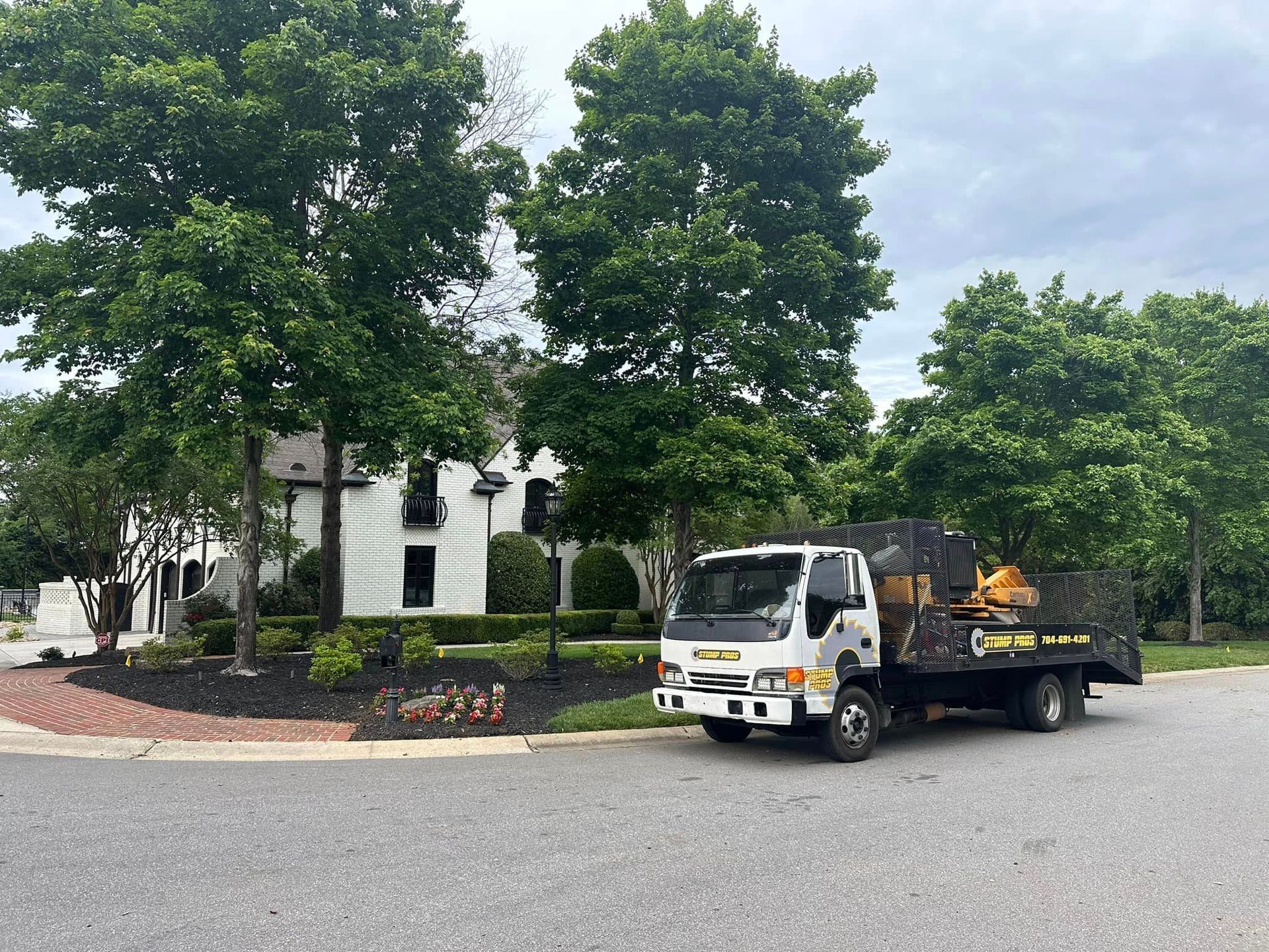 A tow truck is parked on the side of the road in front of a house.