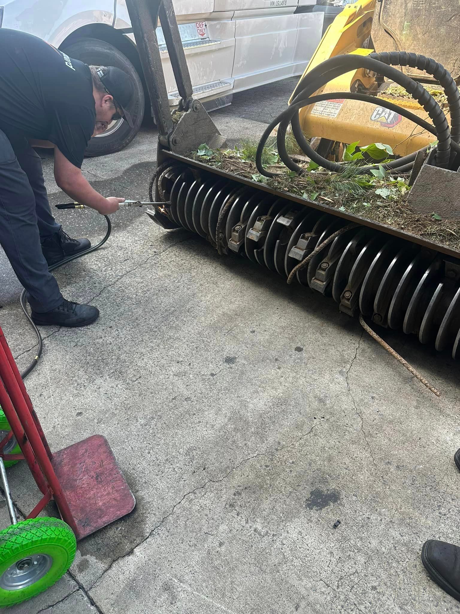 A man is working on a machine on the ground.